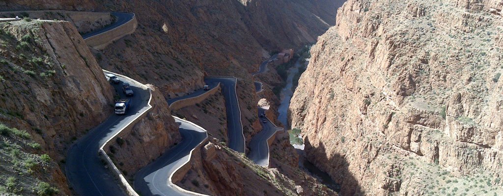 Winding road with hairpin bends through a canyon with steep rock walls