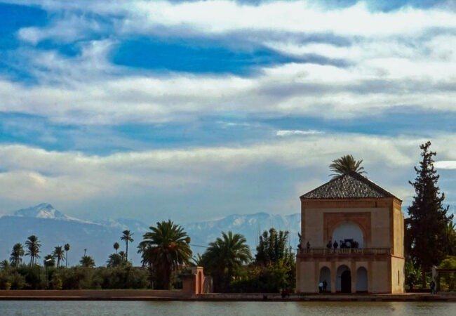 Menara pavilion by its pool in Marrakech with the Atlas mountains in the distance
