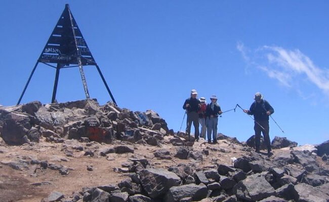 Hikers at the summit marker of Mount Toubkal