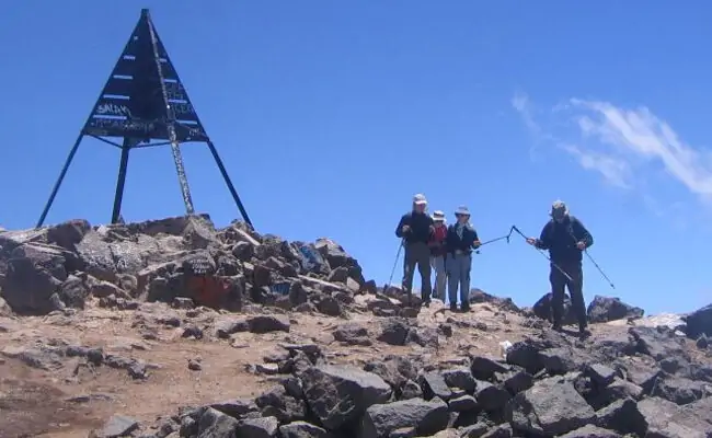 Hikers at the summit marker of Mount Toubkal